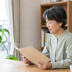 明るい自宅で住宅ローンの相談資料を読む女性