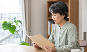 明るい自宅で住宅ローンの相談資料を読む女性