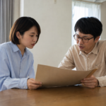 食卓で一つの資料を見ながら話し合う夫婦