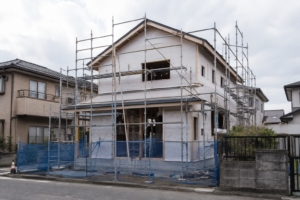 足場に囲まれた建築途中の木造住宅