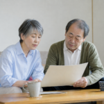 居間で住宅ローンの返済資料を確認する年配の夫婦