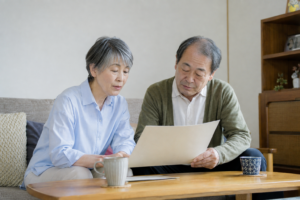 居間で住宅ローンの返済資料を確認する年配の夫婦