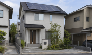 太陽光パネルを屋根に設置した戸建て住宅を道路から見た風景ｈ