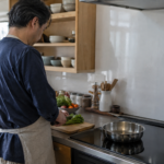 IHのあるキッチンで野菜を準備する男性の後ろ姿