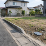住宅地の道路と空き地の境界にある設備のふた